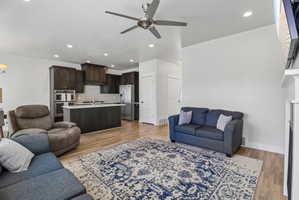 Living room featuring a ceiling fan, light wood-type flooring, recessed lighting, and a fireplace