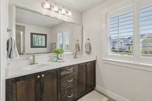 Bathroom with double vanity and baseboards