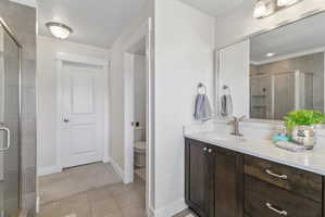 Bathroom with a stall shower, vanity, and light tile patterned flooring