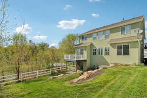 Rear view of house featuring stucco siding and a deck