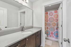 Full bath featuring vanity, light tile patterned floors, and shower / bathtub combination with curtain
