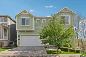 View of front facade featuring board and batten siding, an attached garage, and concrete driveway