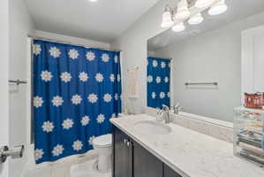 Full bathroom with vanity, light tile patterned flooring, and shower / bath combo