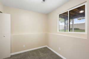 Unfurnished room featuring dark colored carpet and a textured ceiling