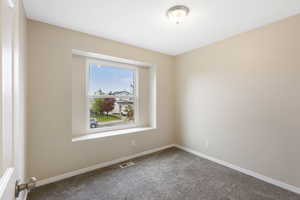 Spare room with carpet and baseboards