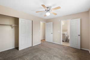 Unfurnished bedroom with a closet, light colored carpet, a ceiling fan, and ensuite bathroom