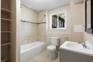 Bathroom with vanity, a textured ceiling, shower / tub combination, and light tile patterned floors