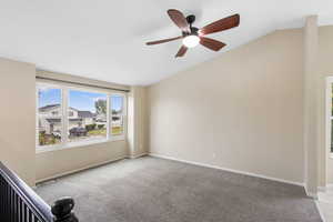 Spare room with light colored carpet, lofted ceiling, and a ceiling fan