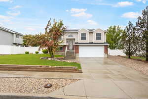 Split foyer home featuring driveway, brick siding, and an attached garage