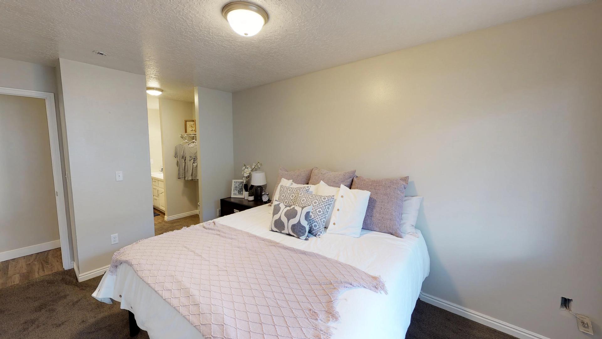 Bedroom featuring dark carpet, a textured ceiling, and ensuite bathroom