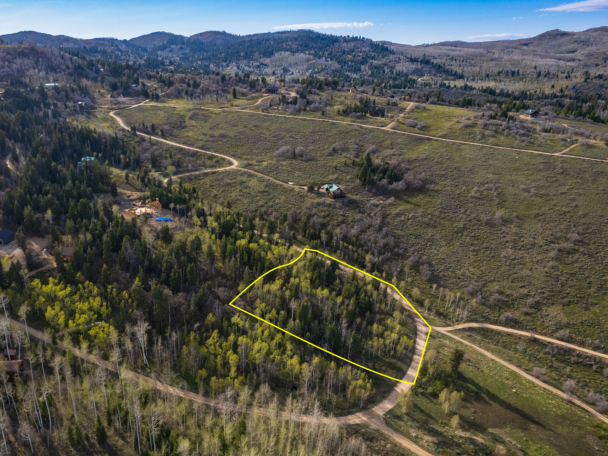 Aerial view of property and surrounding area featuring mountains and property boundaries highlighted