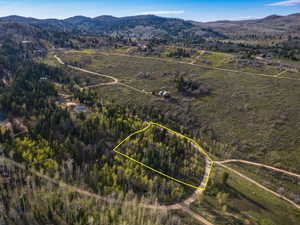 Aerial view of property and surrounding area featuring mountains and property boundaries highlighted