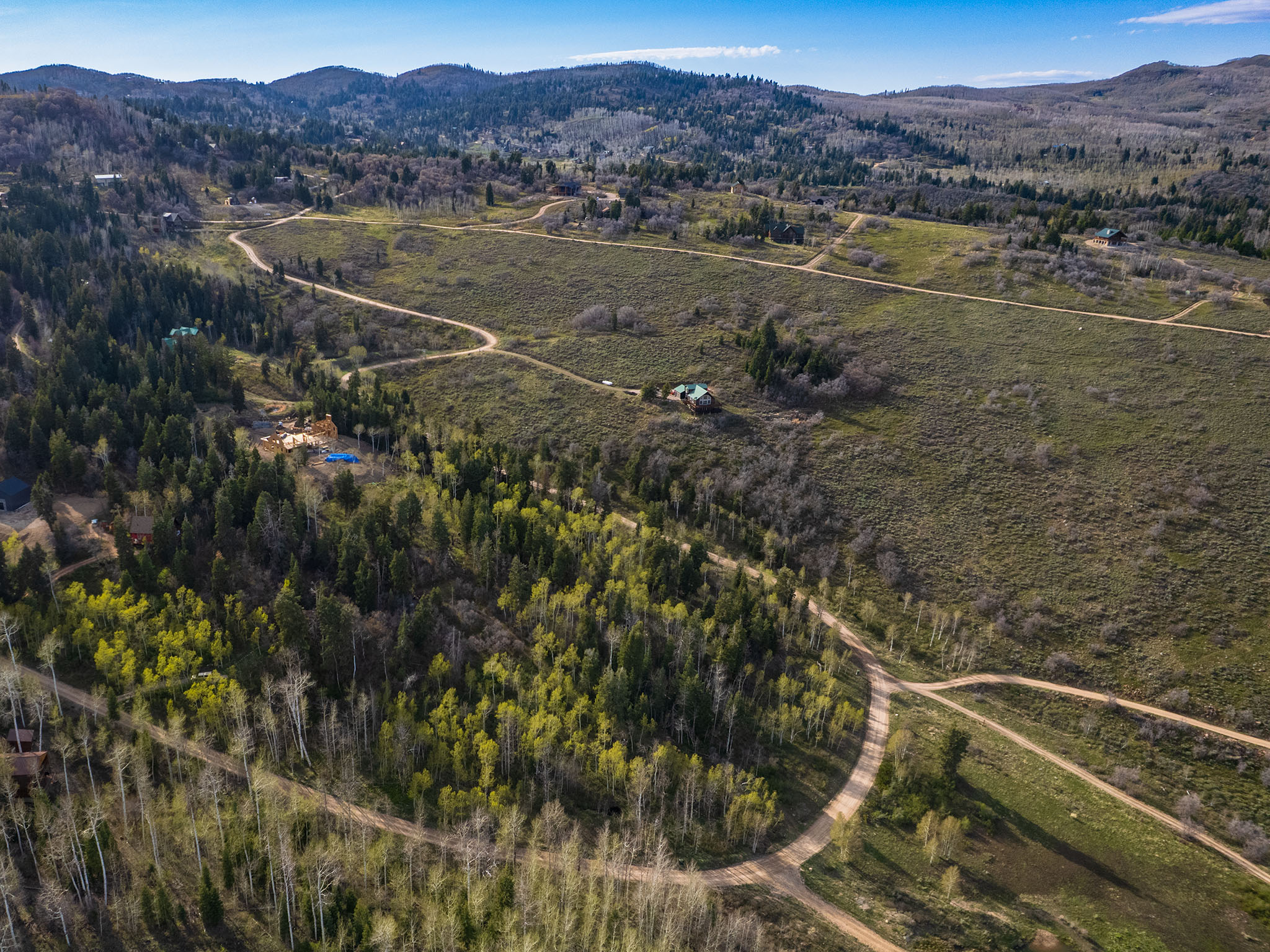 Aerial overview of property's location with a mountain backdrop and property boundaries highlighted