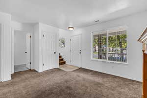 Foyer featuring carpet flooring and stairs