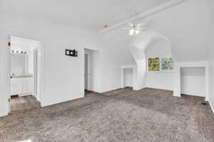 Master bedroom with dark carpet, ceiling fan, and beamed ceiling