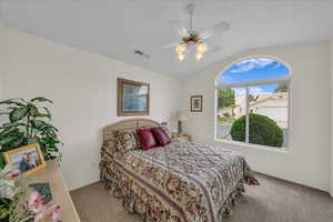 Bedroom featuring vaulted ceiling, carpet, and ceiling fan