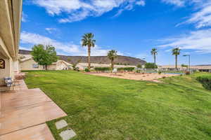 View of green lawn with a patio area and a residential view