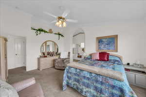 Carpeted bedroom with ornamental molding and a ceiling fan