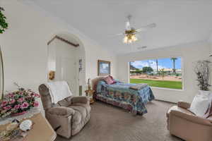 Carpeted bedroom featuring crown molding, ceiling fan, and vaulted ceiling