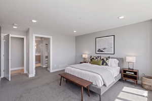 Carpeted bedroom with recessed lighting and ensuite bathroom