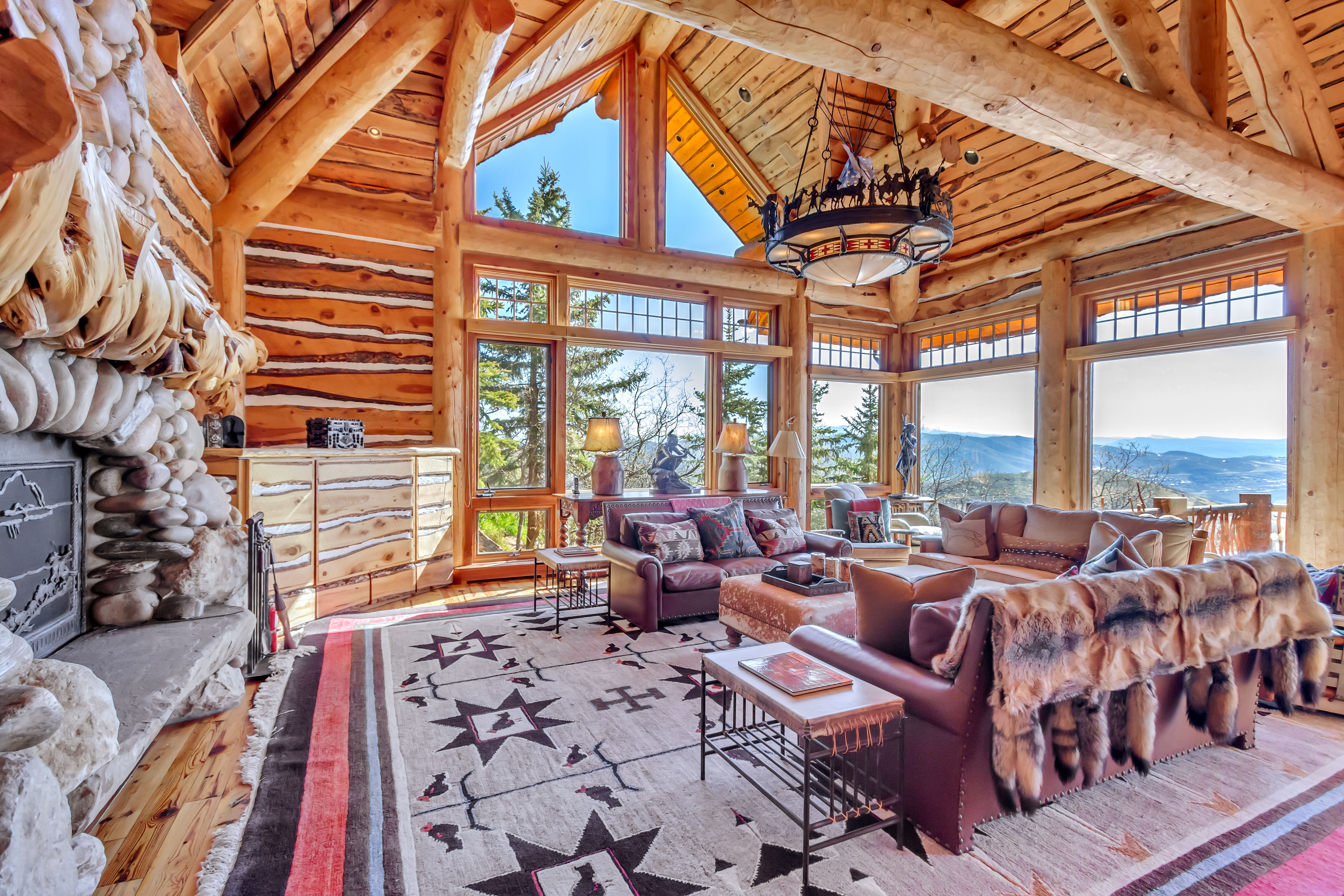 Living area featuring a high wood beamed ceiling, log walls, hardwood / wood-style floors, a mountain view, and plenty of natural light