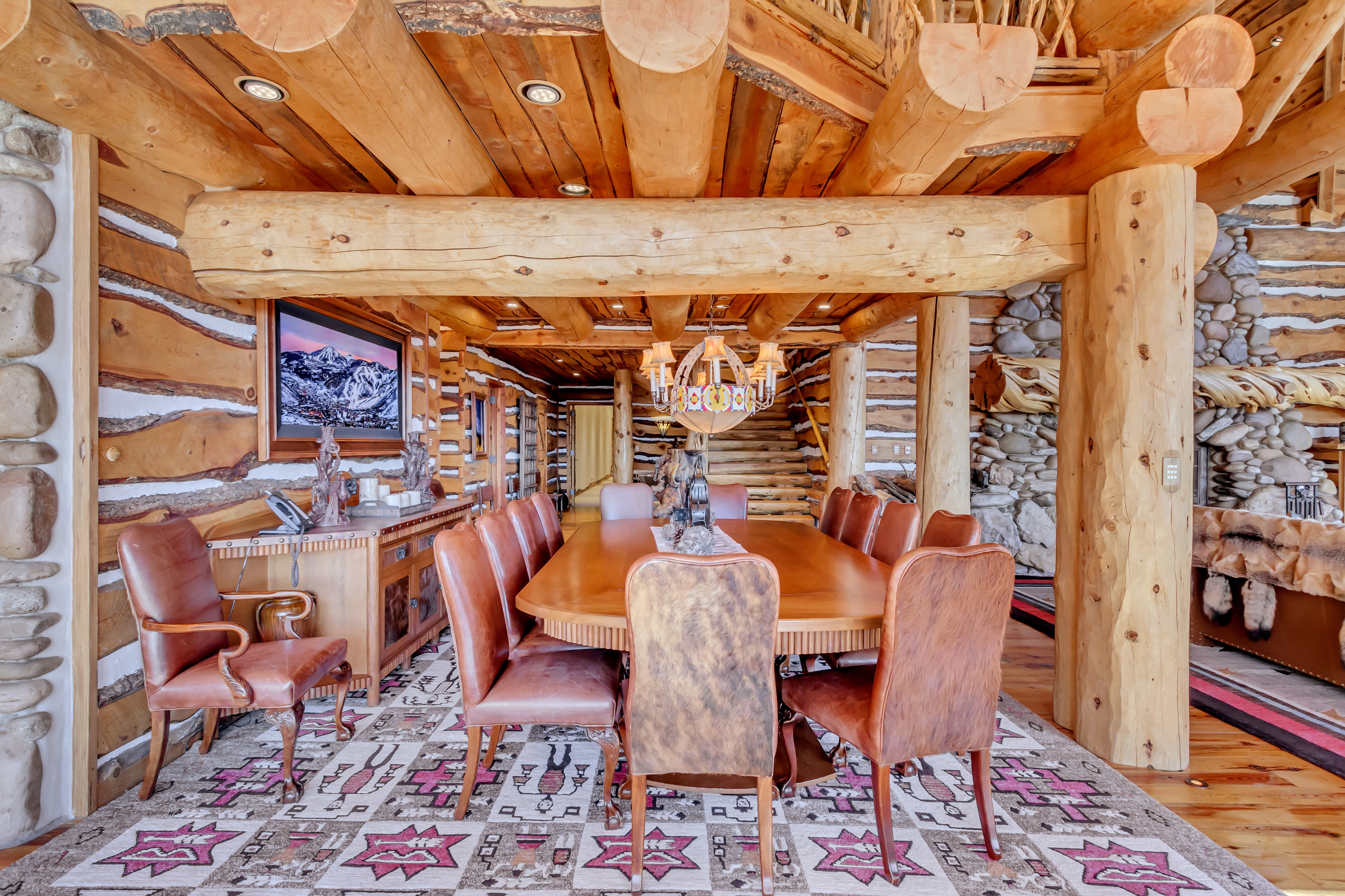 Dining space featuring rustic walls, a wooden ceiling with exposed beams, and wood finished floors
