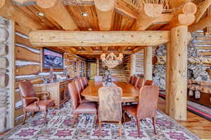 Dining space featuring rustic walls, a wooden ceiling with exposed beams, and wood finished floors