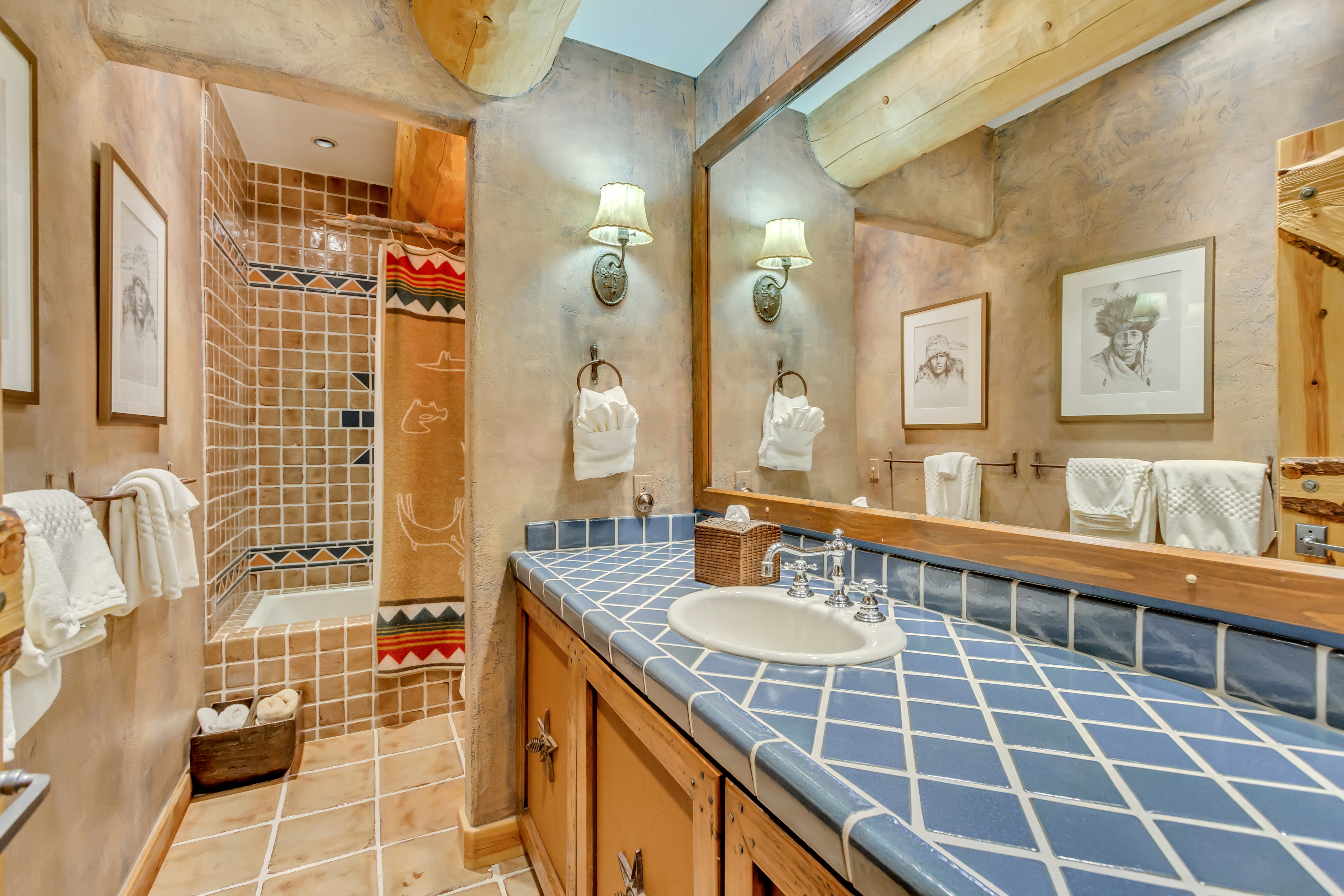 Full bathroom with vanity, tiled shower, and light tile patterned floors