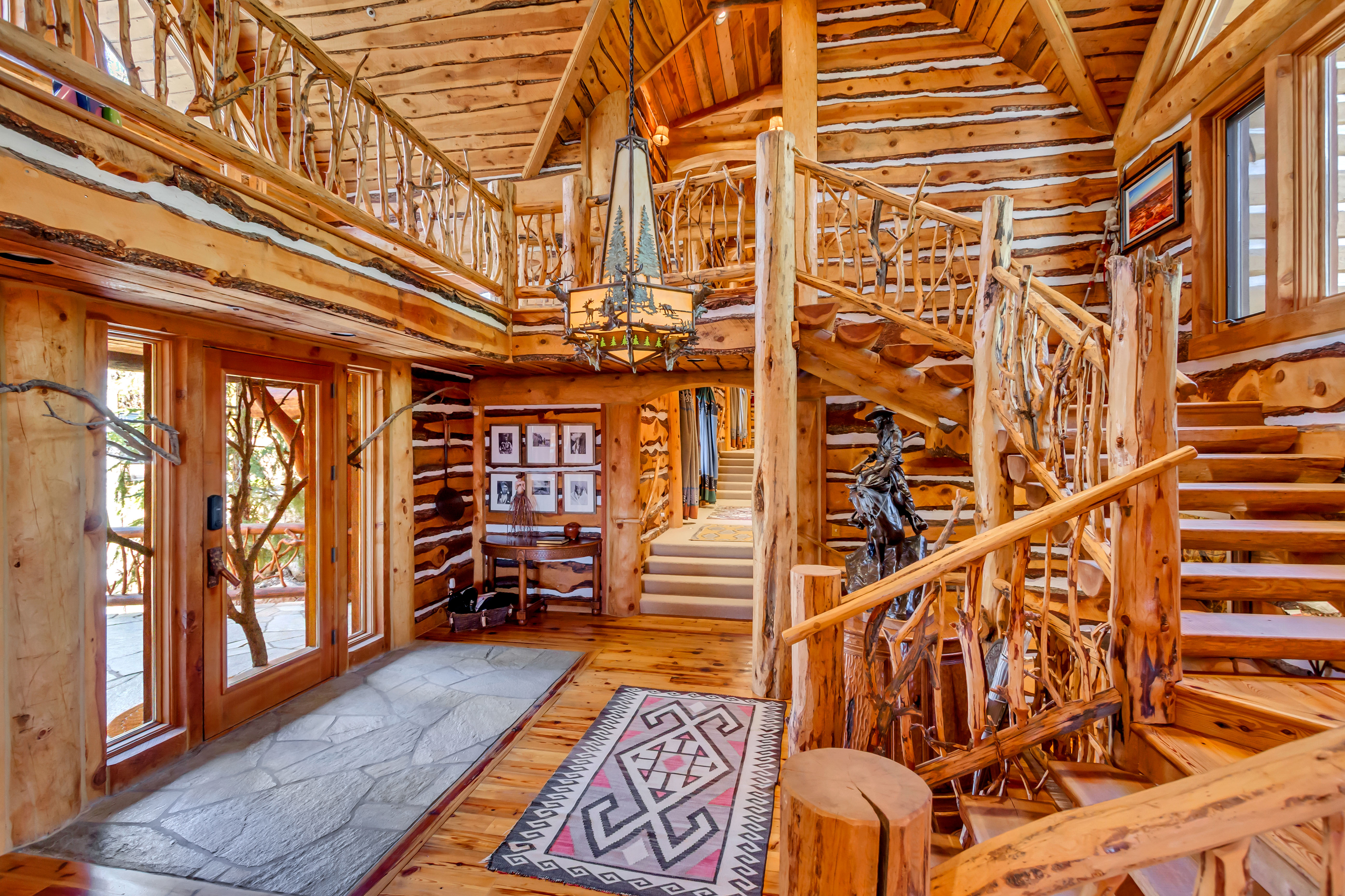 Staircase featuring hardwood / wood-style flooring, hanging lights, a high wooden ceiling, and rustic walls