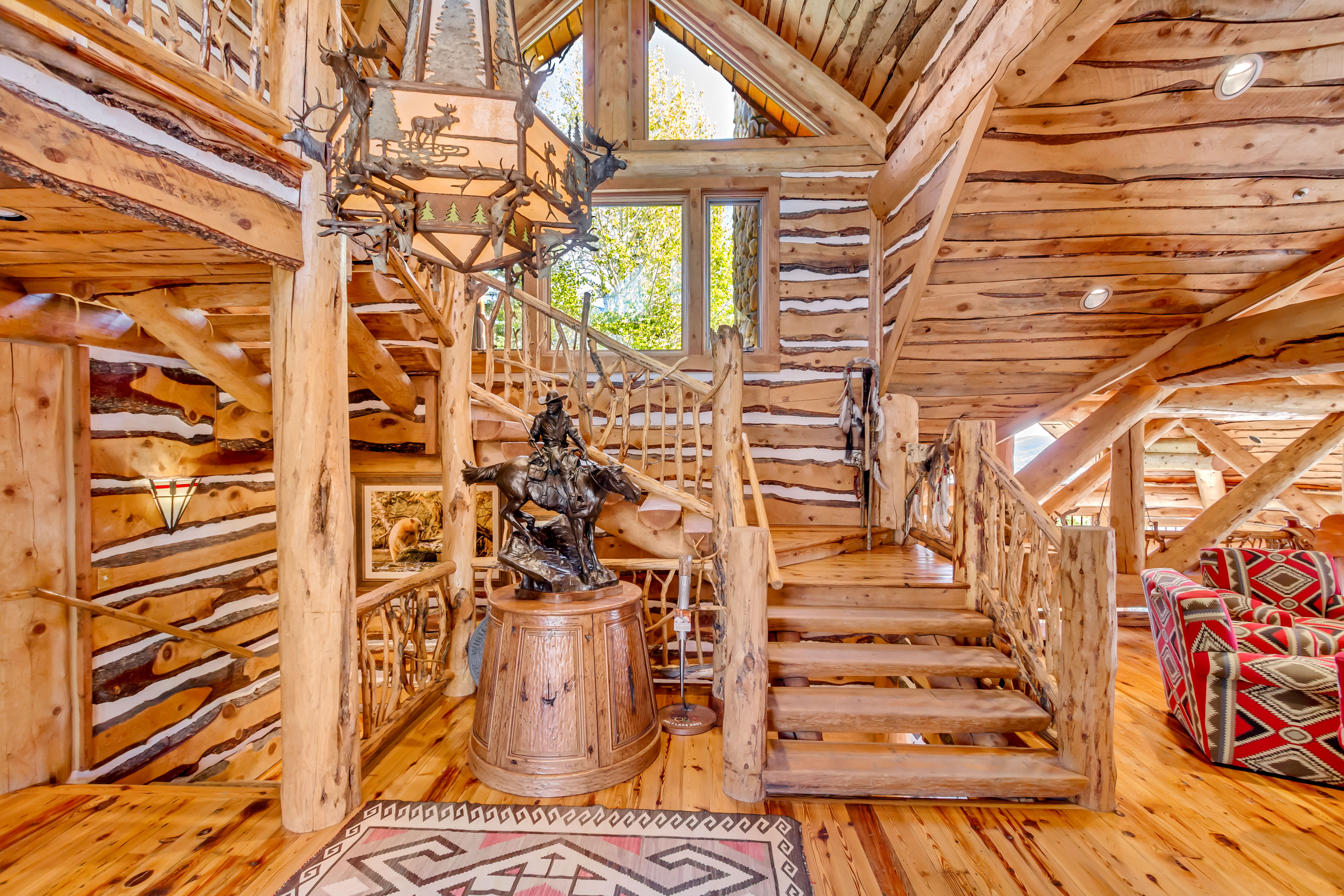 Stairs featuring hardwood / wood-style flooring, wooden ceiling, and log walls