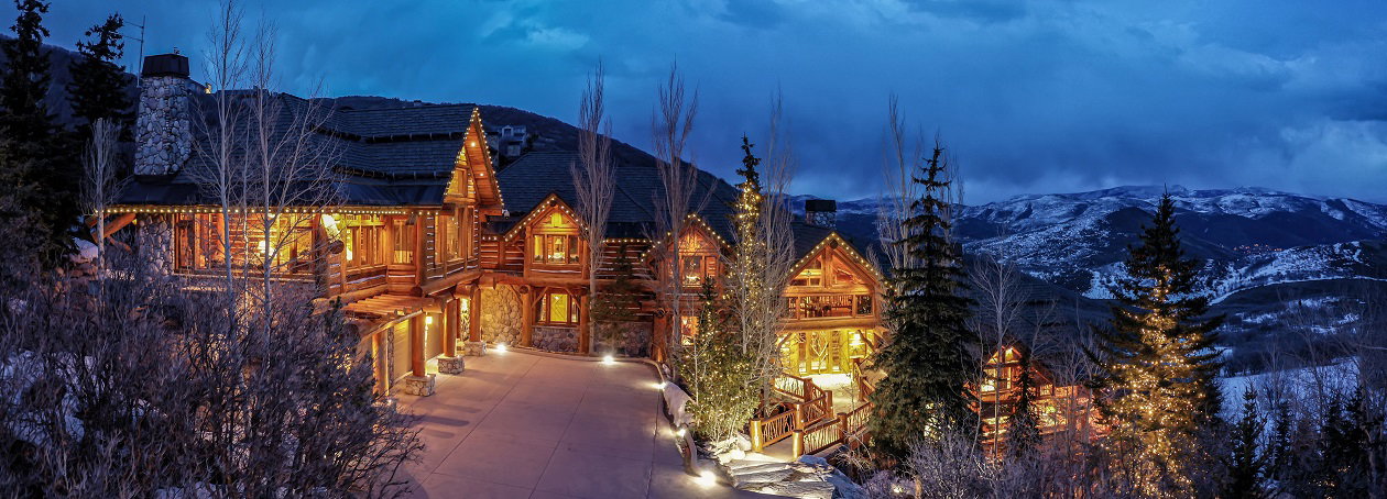 View of front of home with a mountain view, driveway, and a balcony