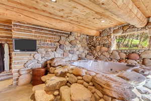 Detailed view of a whirlpool tub, wood ceiling, and recessed lighting