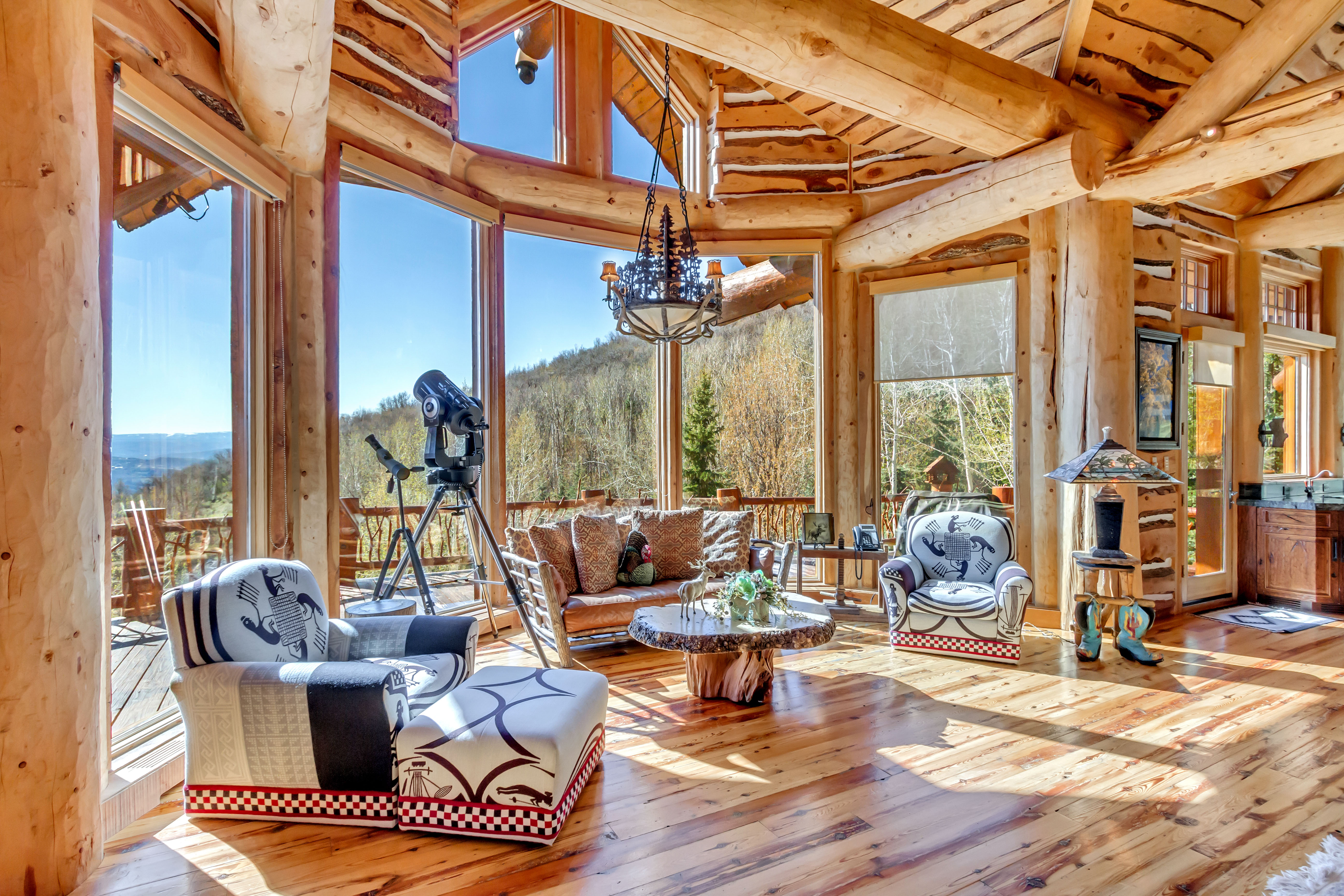 Sunroom with suspended lighting, healthy amount of natural light, and vaulted ceiling with beams