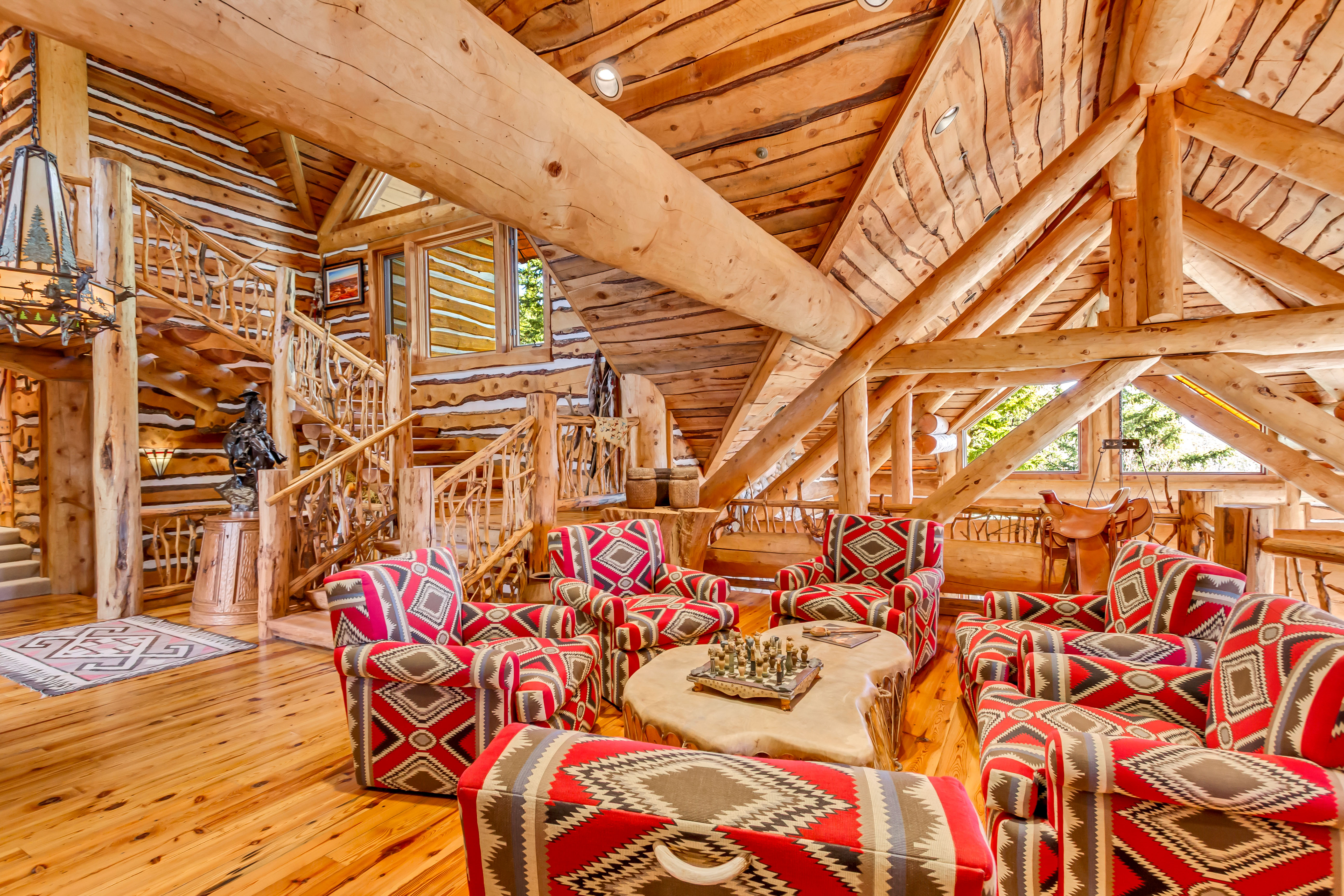Living area with log walls, wood-type flooring, and a wood ceiling with exposed beams