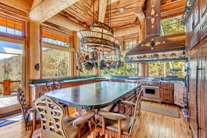 Dining area featuring light wood-style flooring and a high wooden beamed ceiling
