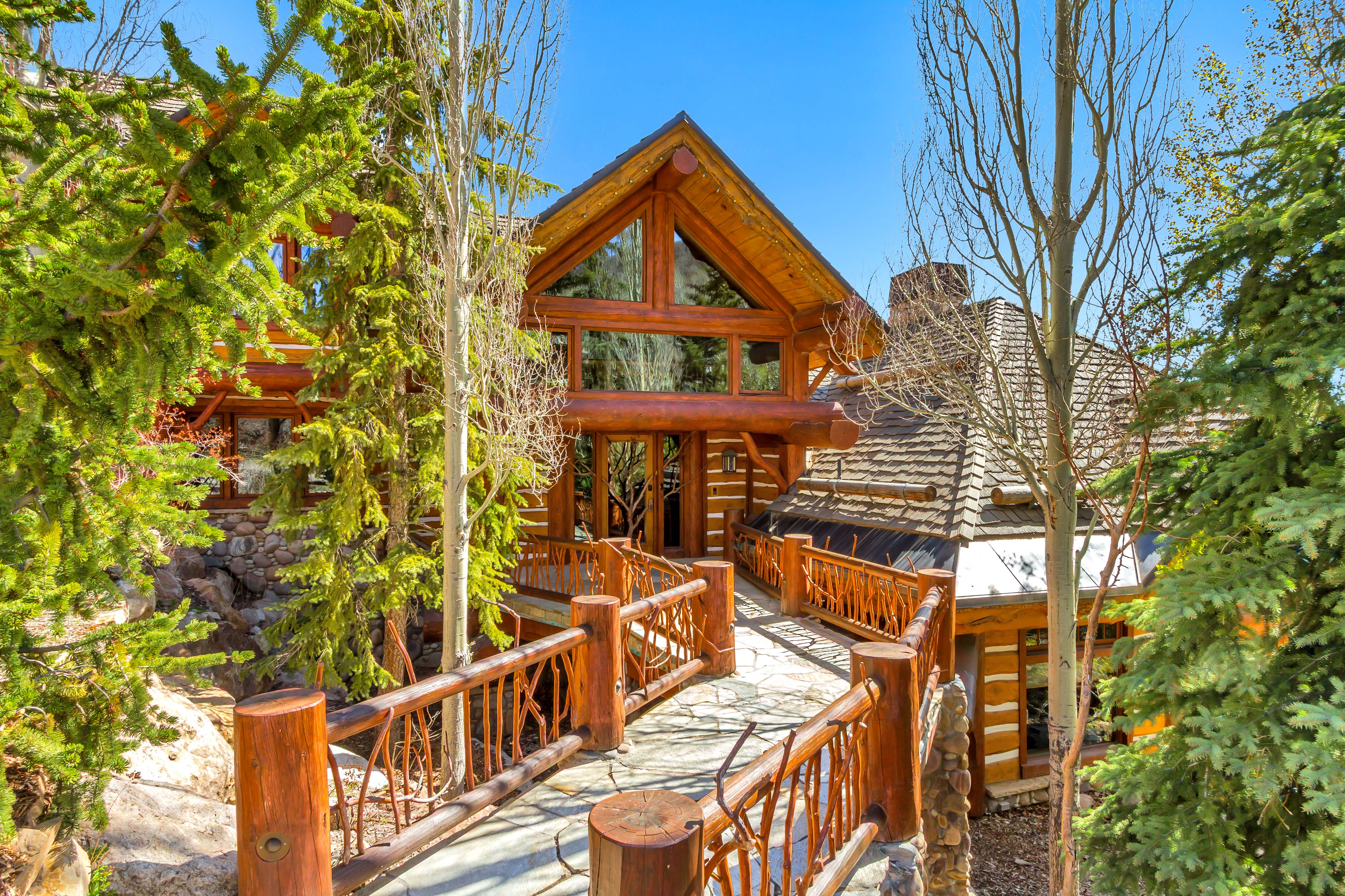 View of front facade featuring a chimney and a wooden deck