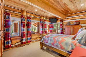 Bedroom with recessed lighting, light colored carpet, and a wood ceiling with exposed beams