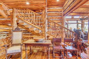 Dining area with hardwood / wood-style floors and log walls