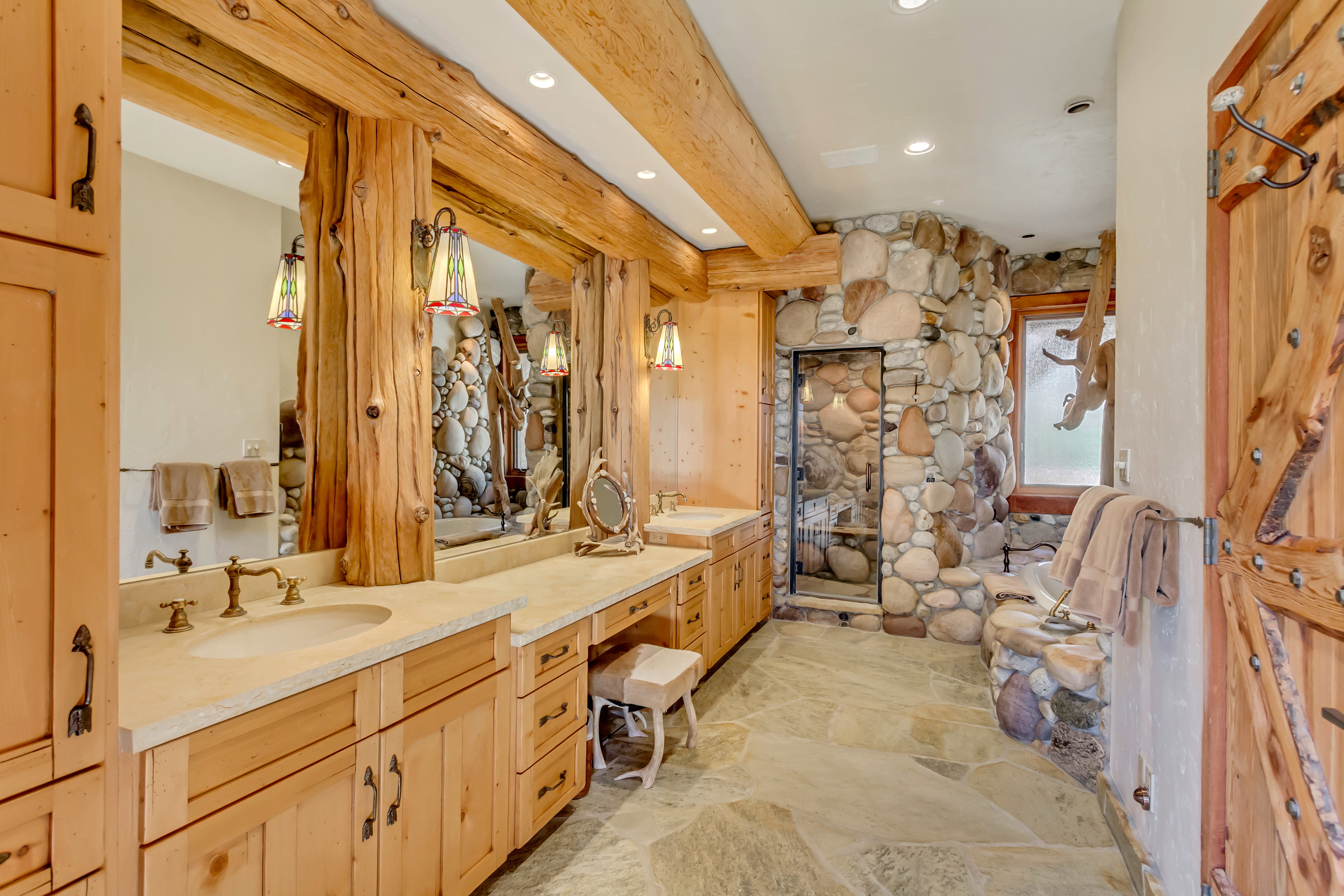 Full bathroom featuring a stall shower, double vanity, beamed ceiling, stone flooring, and recessed lighting