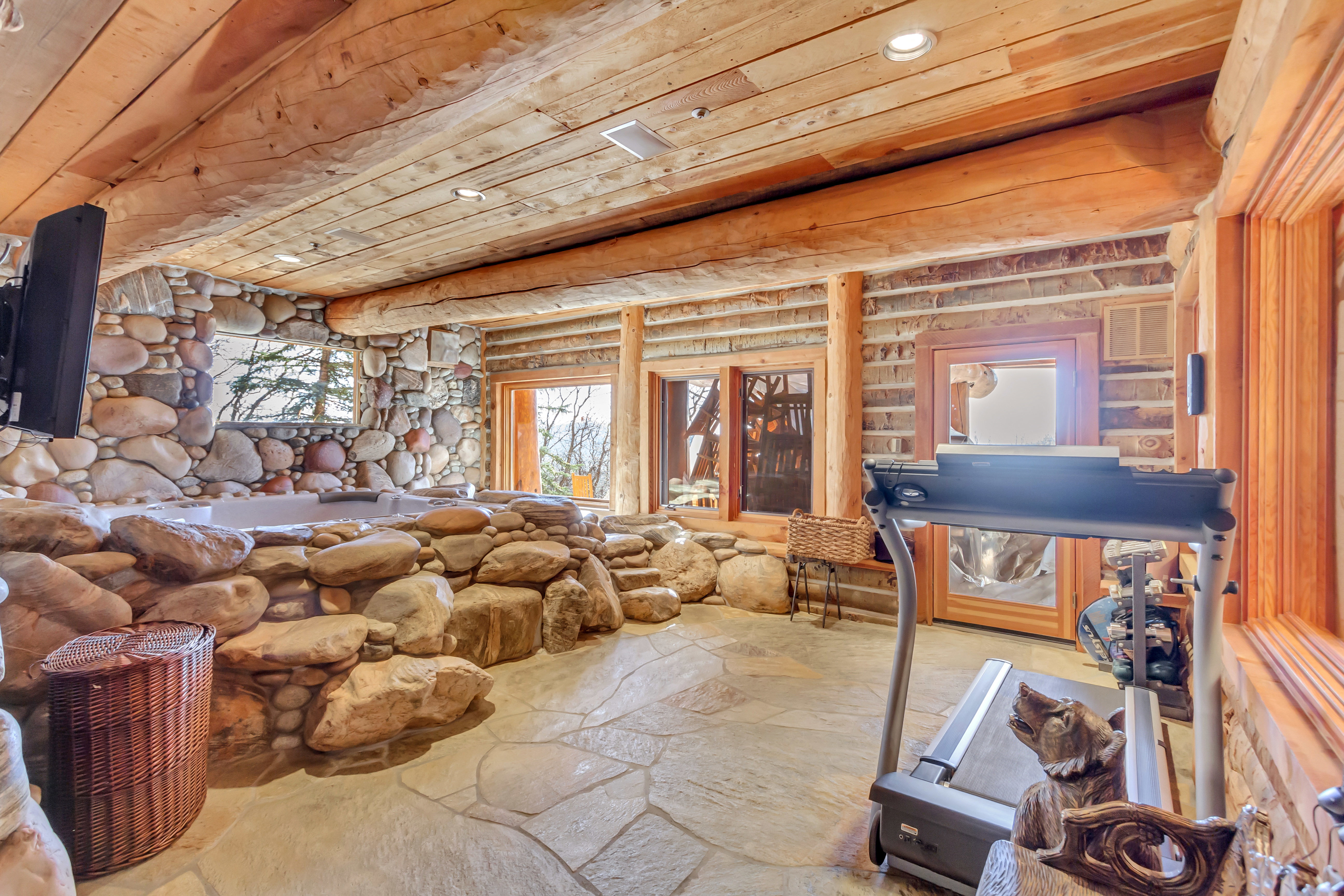 Misc room featuring stone flooring, recessed lighting, log walls, and wooden ceiling