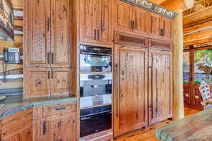 Kitchen featuring wood finish cabinets, oven, and paneled refrigerator
