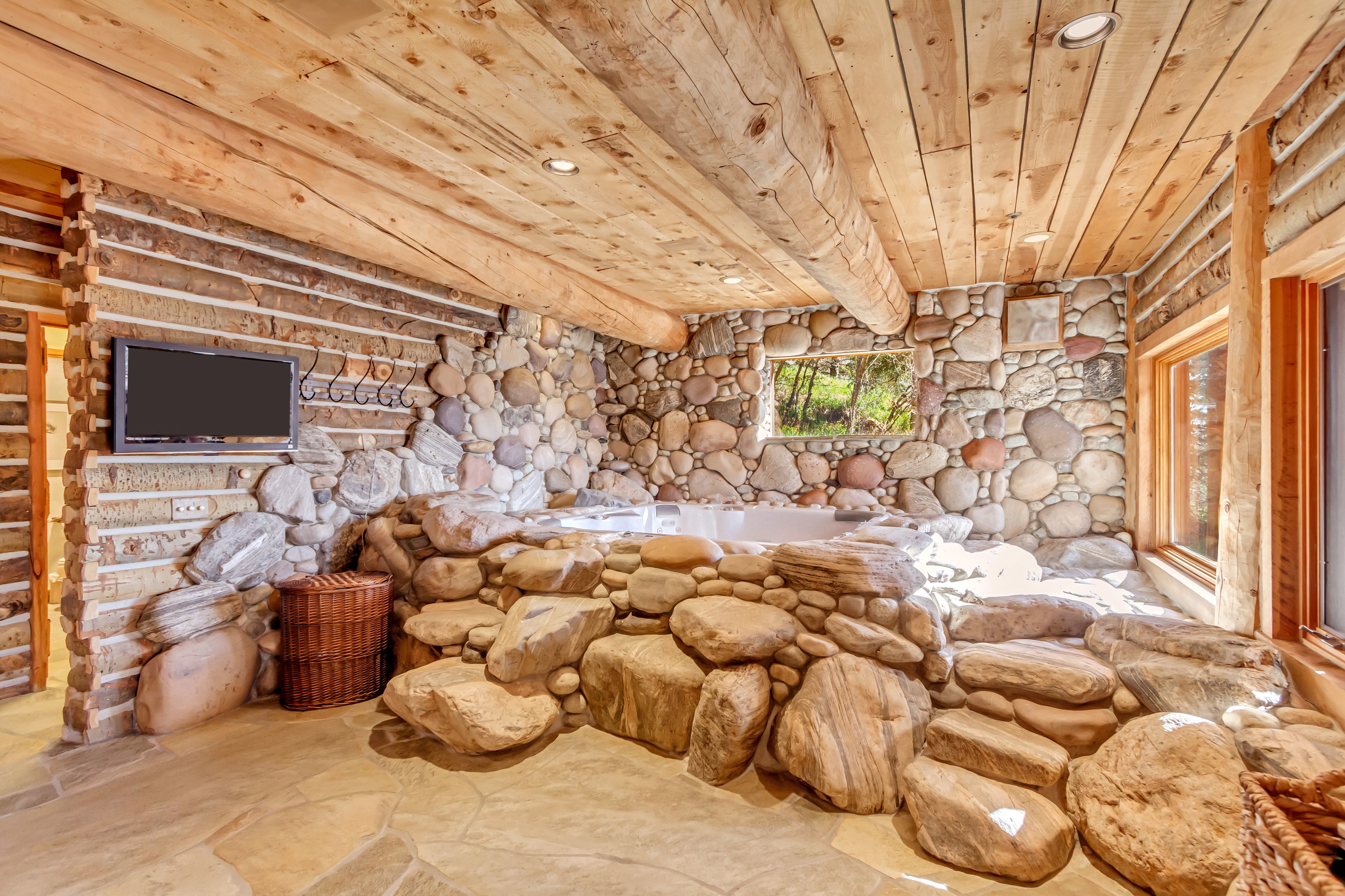 Unfurnished bedroom featuring wood ceiling and stone floors