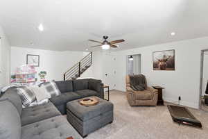 Living room featuring a ceiling fan and carpet flooring