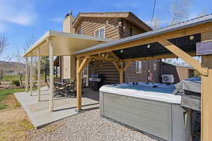 View of patio / terrace with grilling area, a hot tub, and outdoor dining area