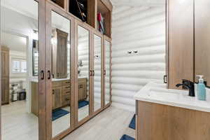 Full bath featuring double vanity and rustic walls