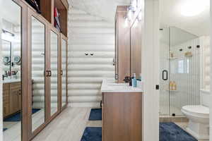 Full bathroom featuring vanity, a stall shower, and a textured ceiling