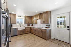 Kitchen featuring wood finish cabinets, light wood finished floors, stainless steel appliances, backsplash, and recessed lighting