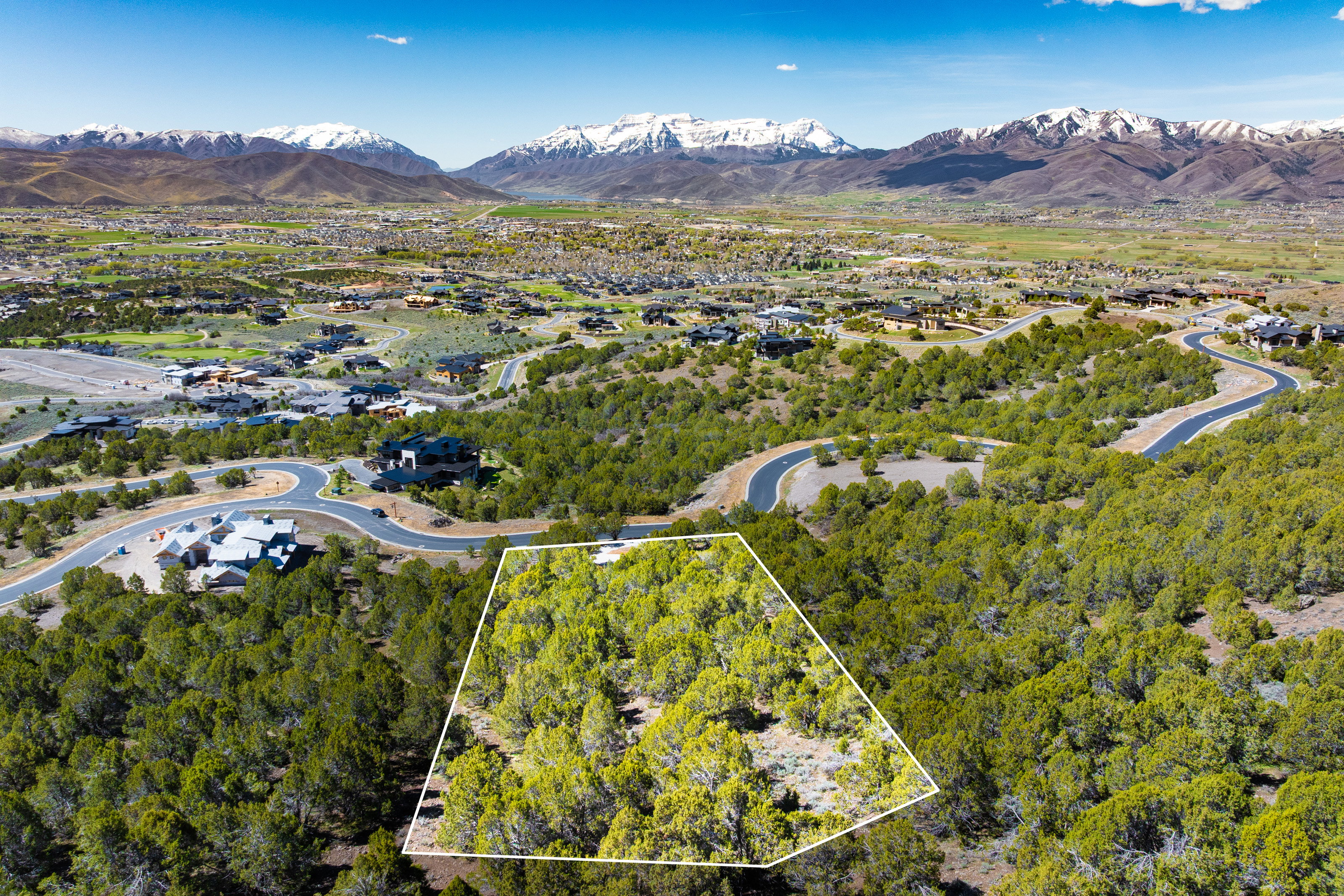 Aerial view of property and surrounding area featuring mountains and property parcel outlined