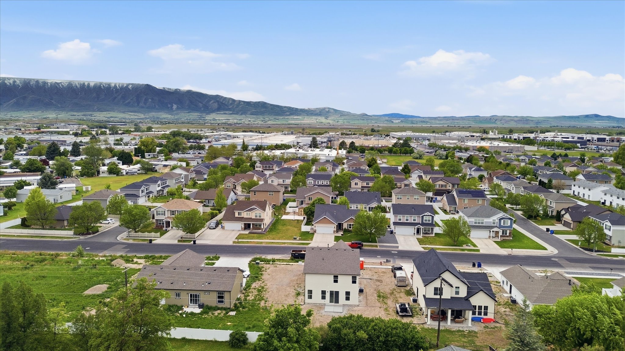 Sprawling residential neighborhood with established homes, mature landscaping, and mountain backdrop