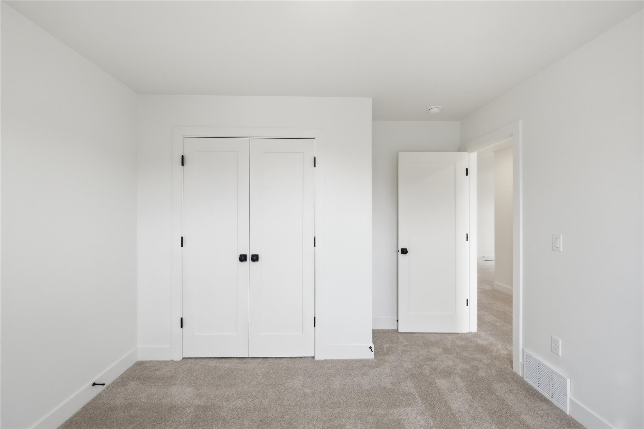 Neutral interior featuring light gray carpeting, white walls, and white trim